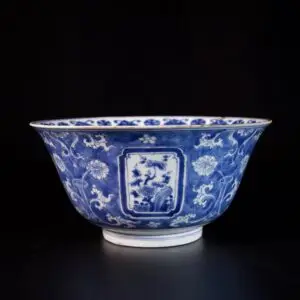 Photo d'un large bol en porcelaine d'époque Kangxi à décor bleu et blanc de rinceaux de lotus et de fleurs de prunus.
