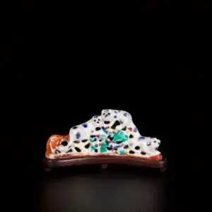 Photo d'un repose-pinceaux en porcelaine aux émaux de la Famille Rose d'époque Jiaqing représentant des écureuils. Il repose sur un socle en bois.