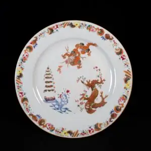 Assiette en porcelaine d'époque Qianlong aux émaux de la Famille Rose à décor d'un dragon, d'une pagode et d'un arbre en fleurs.