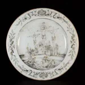 Photo d'une assiette en porcelaine d'époque Qianlong, à décor en grisaille de la crucifixion du Christ, la bordure est décorée dans le style Du Paquier.