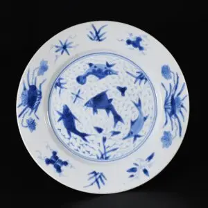 Photo d'une assiette en porcelaine d'époque Kangxi à décor bleu et blanc de poissons.