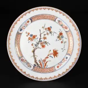 Photo d'une assiette en porcelaine d'époque Kangxi à décor rouge de fer d'un arbre fleuri.