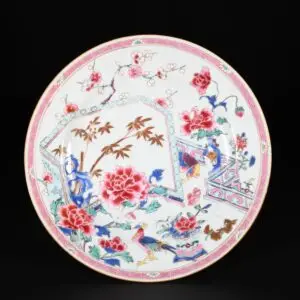 Photo d'une assiette d'une paire d'assiettes d'époque Yongzheng aux émaux de la Famille Rose à décor d'un balcon fleuri.