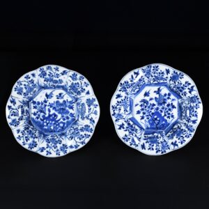 Photo d'une paire d'assiettes en porcelaine d'époque Kangxi à décor bleu et blanc d'un rocher percé et d'oiseaux en vol.