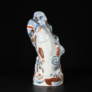 Photo d'un vase mural en porcelaine de la période Edo, du XVIIe siècle, figurant une carpe bondissante.