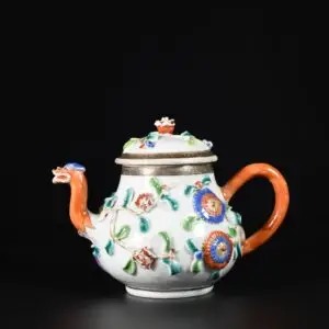 Photo d'une théière en porcelaine d'époque Yongzheng, aux émaux de la Famille Rose à décor de fleurs en relief, le bec en forme de dragon.