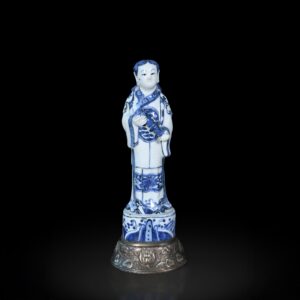 Photo d'une figure en porcelaine d'époque Wanli représentant un Immortel tenant un rouleau à décor bleu et blanc.