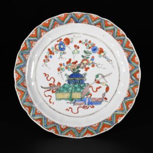 Photo d'une assiette en porcelaine d'époque Kangxi aux émaux de la Famille Verte à décor central d'antiquités.