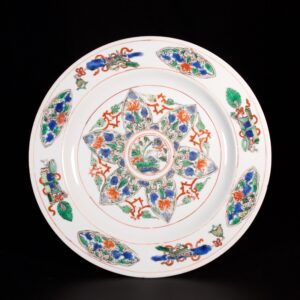 Photo d'une assiette en porcelaine d'époque Kangxi décorée dans les émaux de la Famille Verte d'attributs bouddhiques.