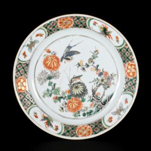 Photo d'une assiette en porcelaine d'époque Kangxi, décorée dans les émaux de la Famille Verte d'un oiseau en vol et d'une sauterelle.