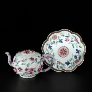 Photo d'une théière en porcelaine d'époque Yongzheng à décor de fleurs en relief. Elle est accompagnée de son pattipan.