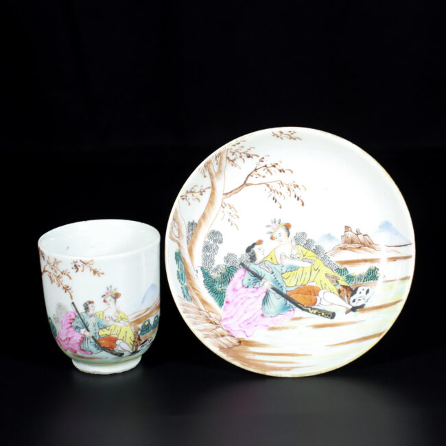 Photo d'une tasse et sa soucoupe en porcelaine d'époque Qianlong à décor polychrome d'un chasseur et une femme sous un arbre.